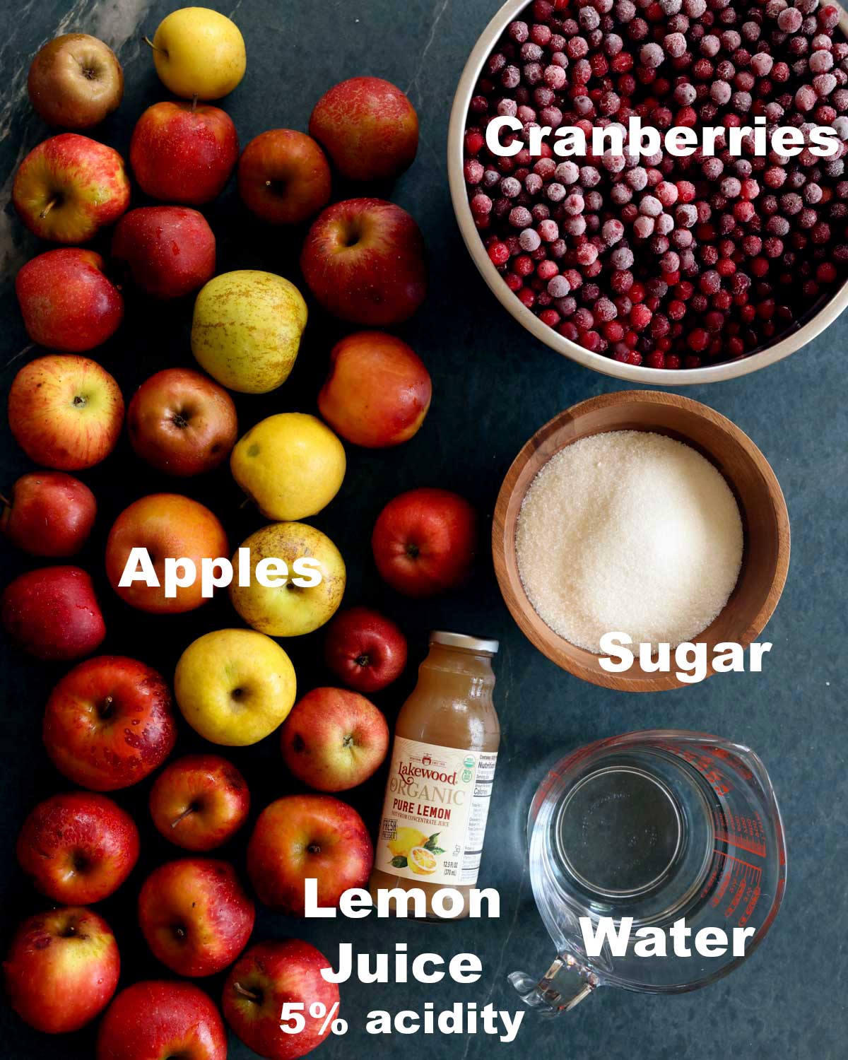 The ingredients of cranberry applesauce including apples, sugar, lemon juice, and water.