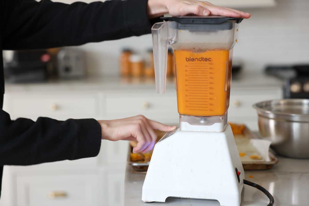 Pumpkins flesh is scraped out and placed in a blender to puree.