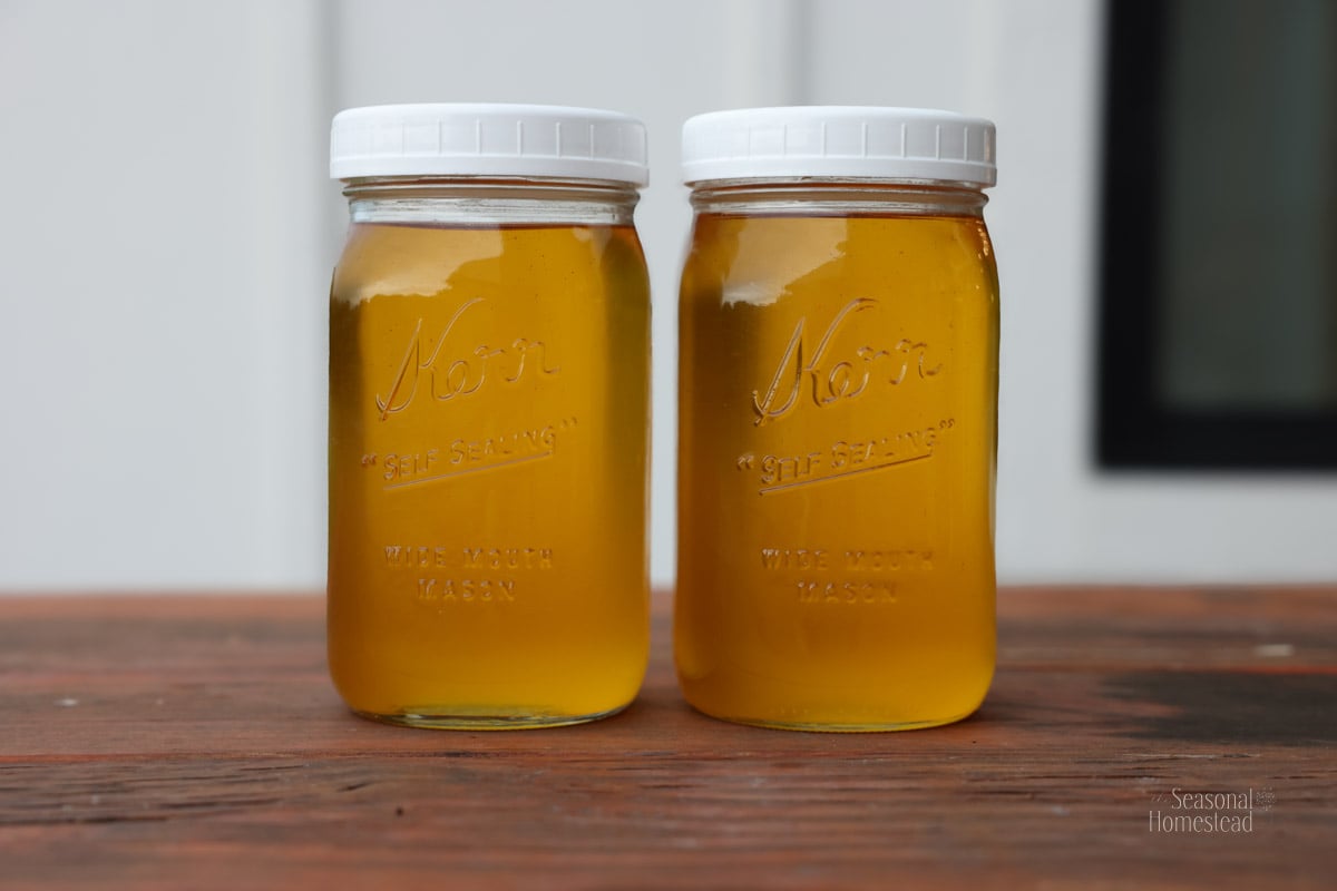 two jars of warm tallow (liquid gold) on a counter.