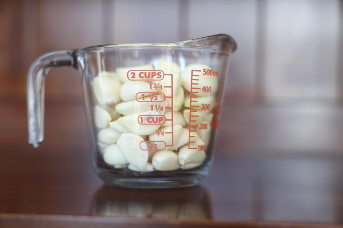 Peeled garlic in a measuring cup.