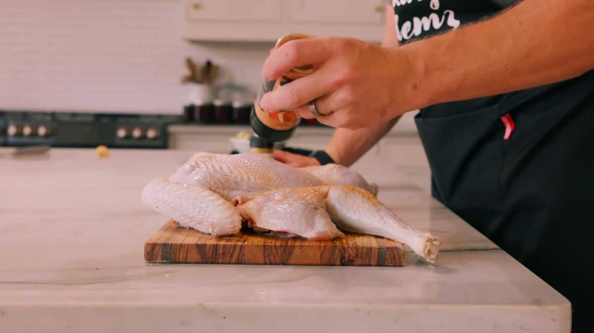 adding butter and seasoning to a turkey