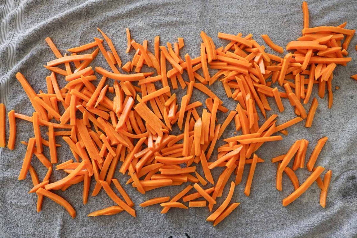 Sweet potatoes are laid out on a towel to dry.