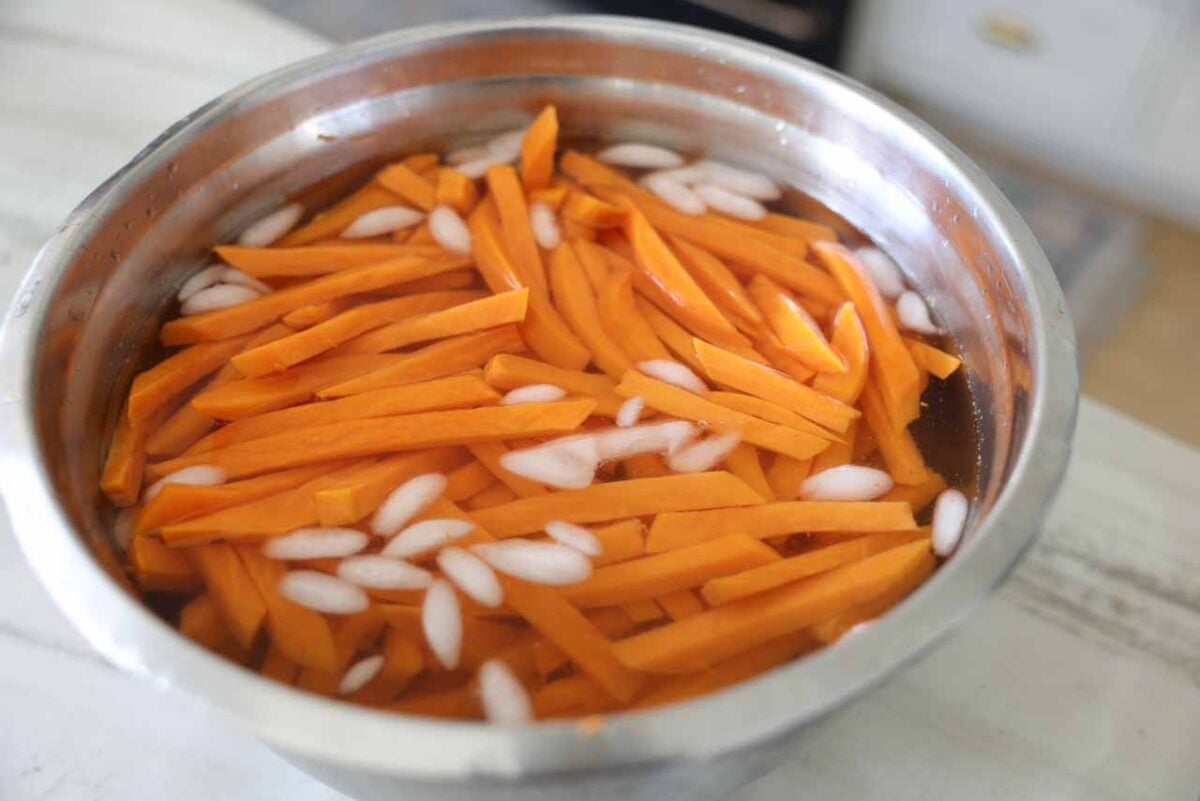 Sweet potatoes are put in an ice bath following blanching.