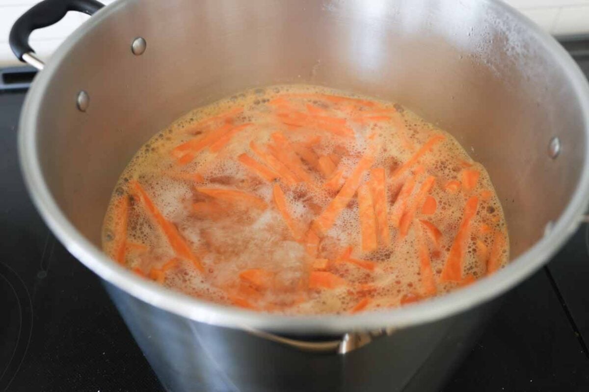 Sweet potato fries in a pot of almost boiling water.