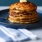 A stack of multigrain pancakes with butter on top.