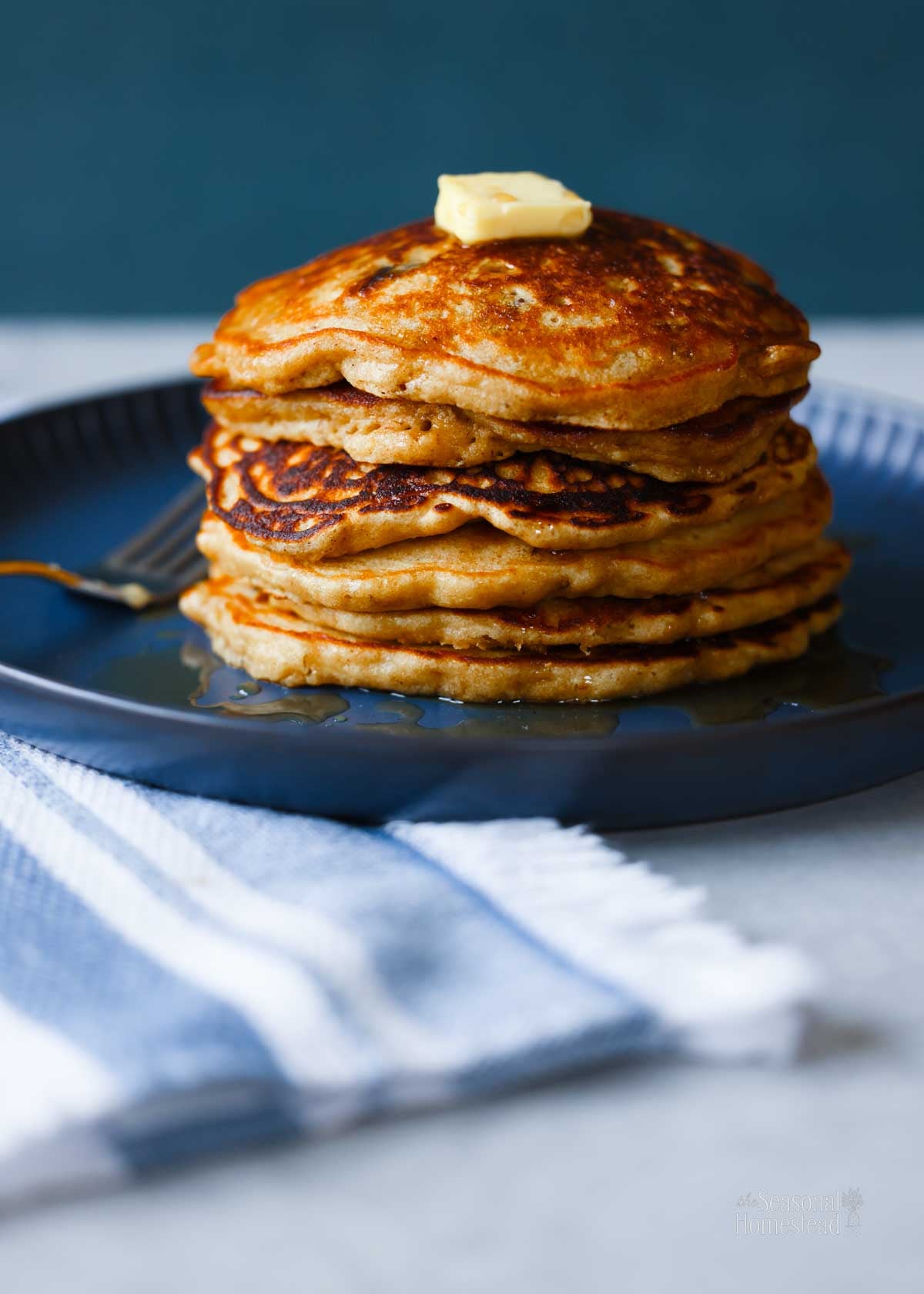 A stack of multigrain pancakes with butter on top.