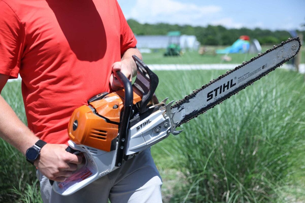 A man holds a chainsaw.