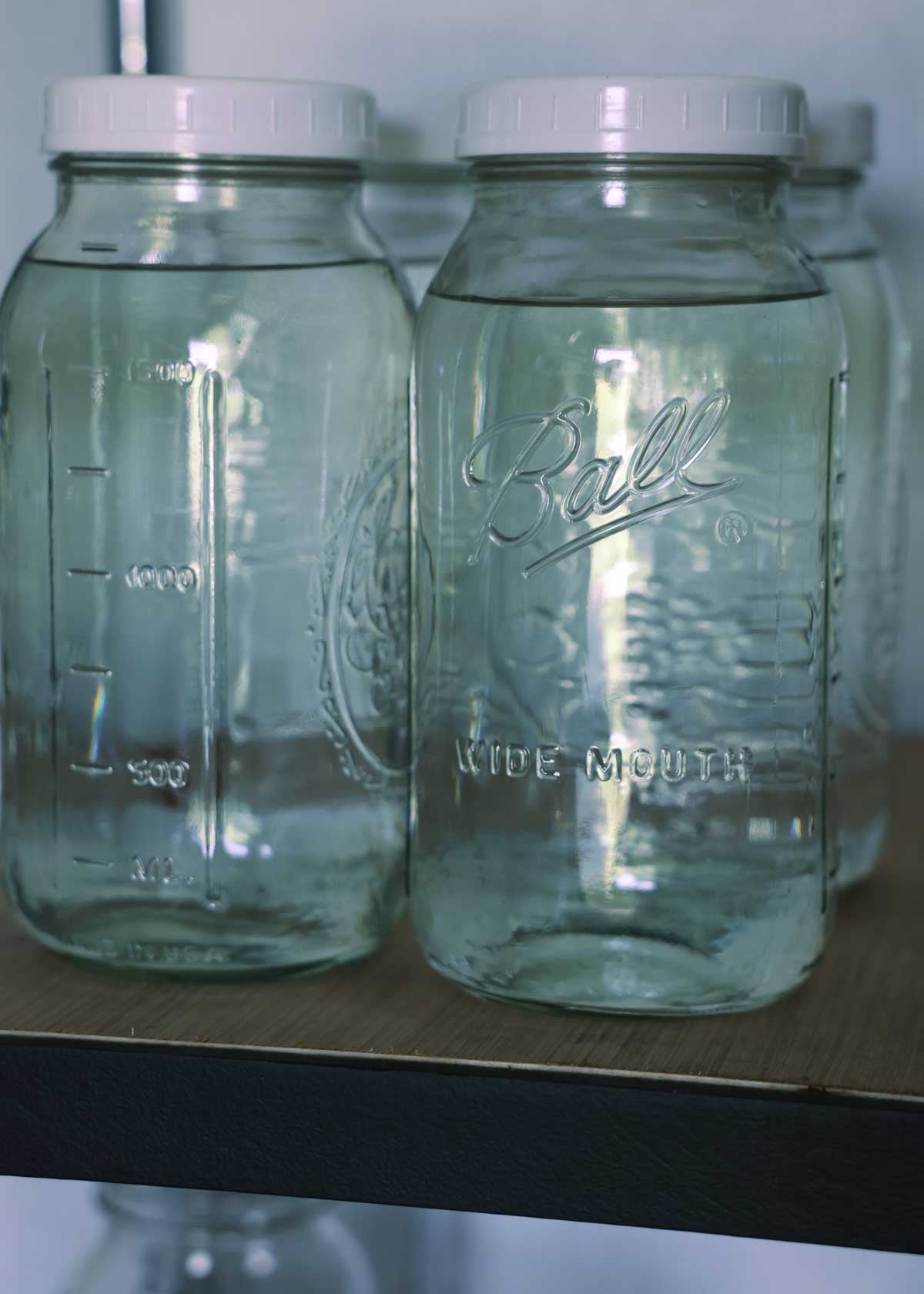 Water storage in half gallon mason jars on a shelf.