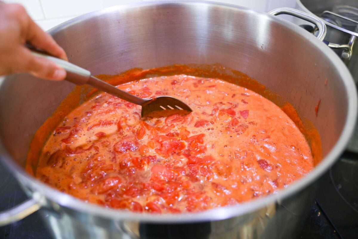 The diced tomatoes are heated in a large saucepan.
