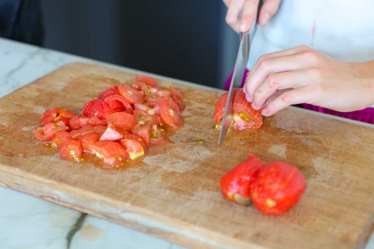 Chopping up whole, skinned tomatoes into chunks for diced tomatoes.