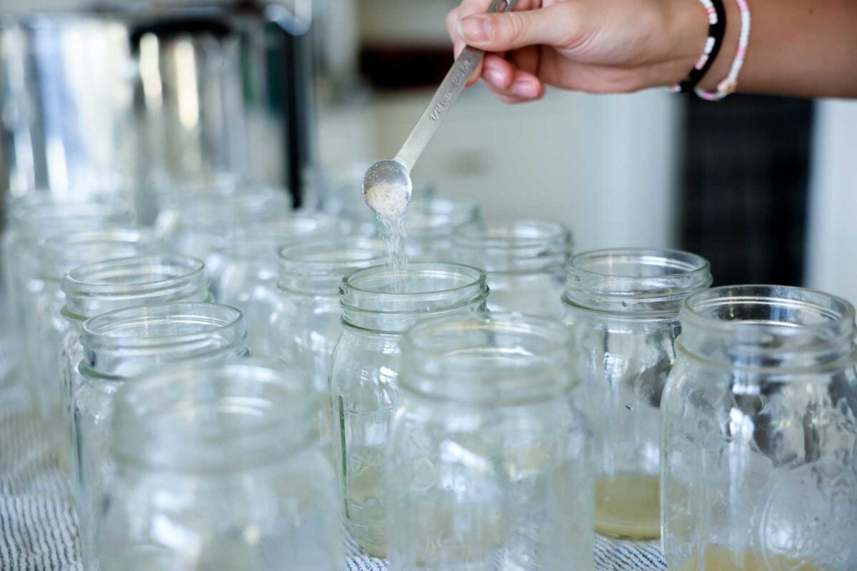 Sea salt is poured into each mason jar.