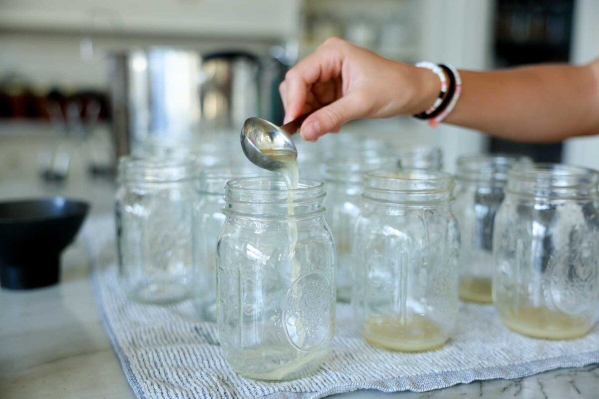 Bottle lemon juice is poured into jars for the canner.